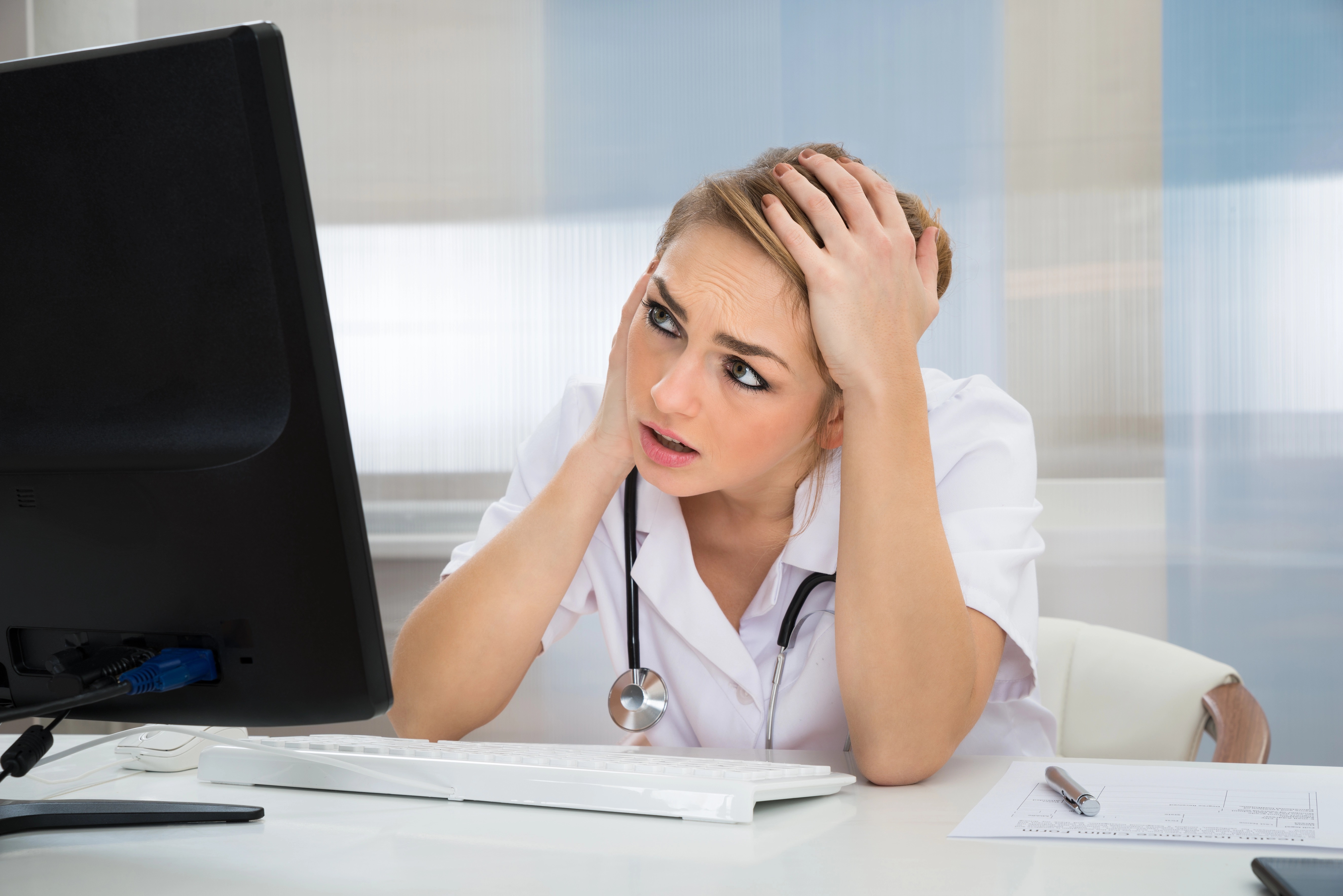 Woman staring at laptop in distress